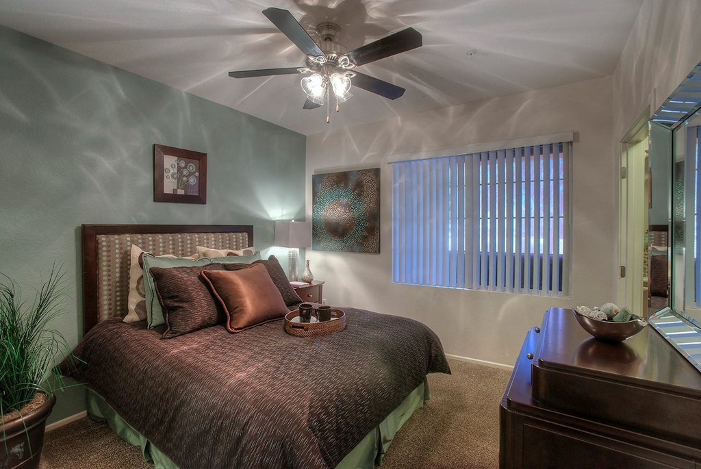 a bedroom with a bed and a ceiling fan