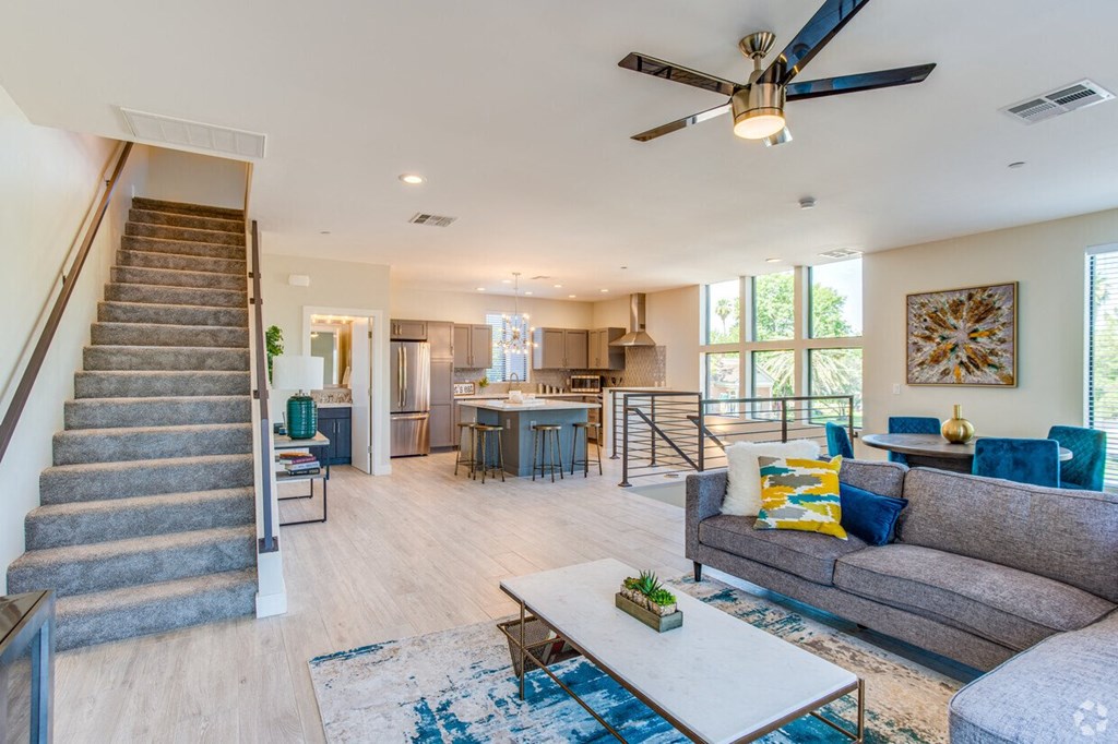 a living room with a staircase and a ceiling fan