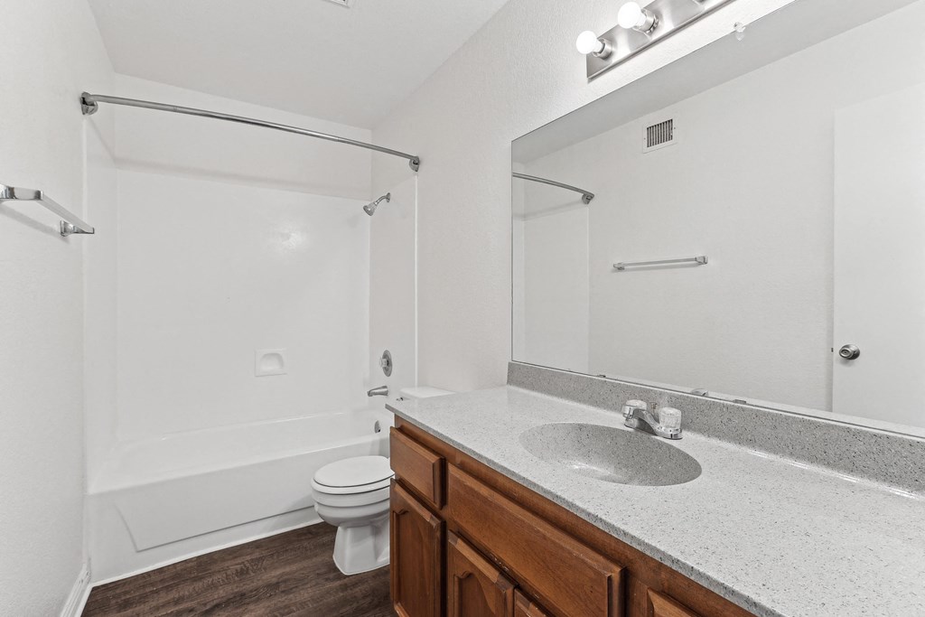 A white bathroom with a toilet, sink, and bathtub.