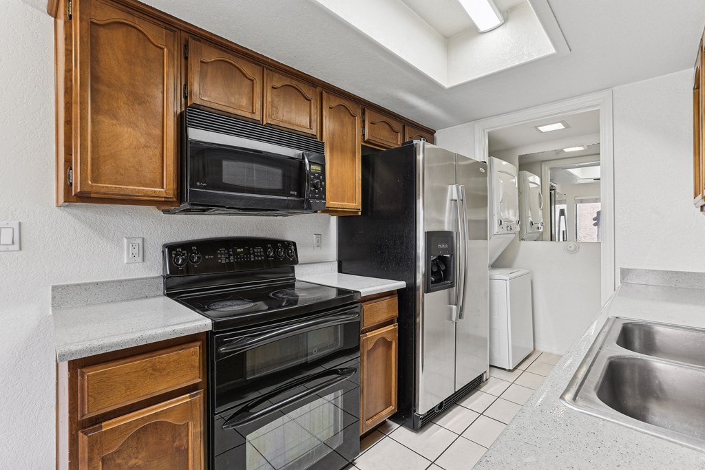 A kitchen with black appliances and wooden cabinets.