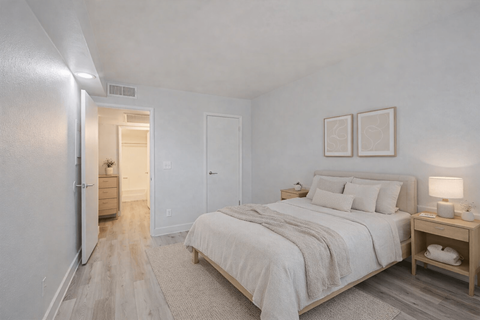 A bedroom with a large bed and a nightstand.