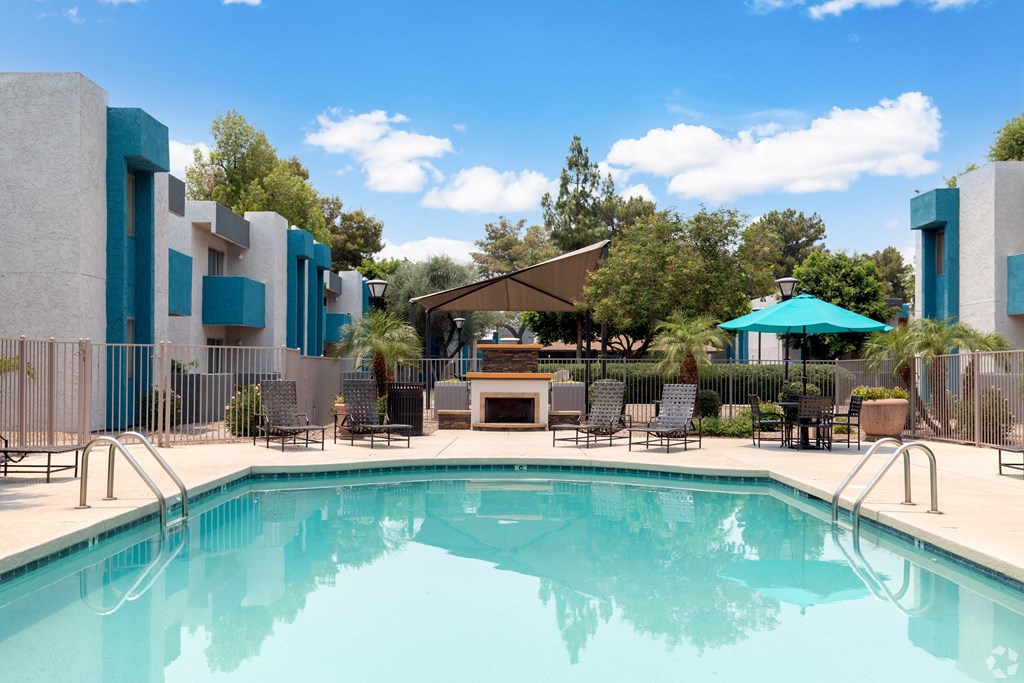 A swimming pool in front of a modern building. at Sycamore Square  Apartments, Mesa, AZ