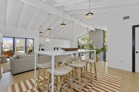 A white dining room with a long table and chairs.