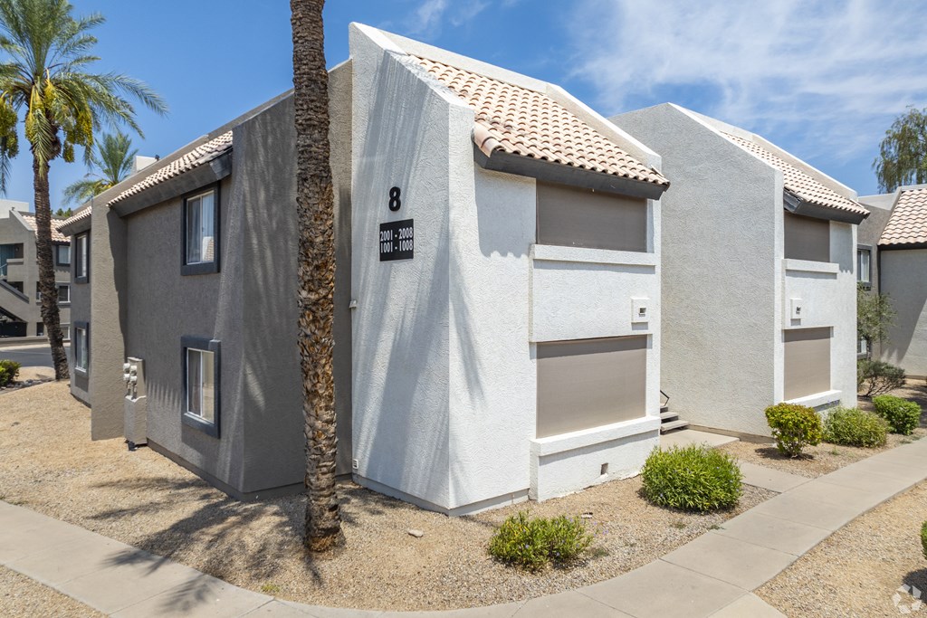 a white and gray house with palm trees in front of it