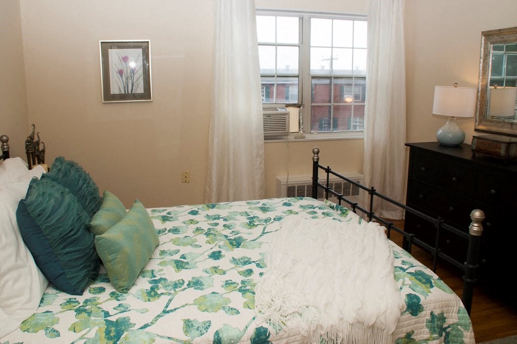 bedroom with bed, dresser, and large window at ridgecrest village in washington dc