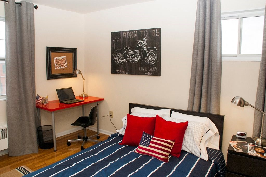 bedroom with bed, desk, chair and large windows at ridgecrest village in washington dc