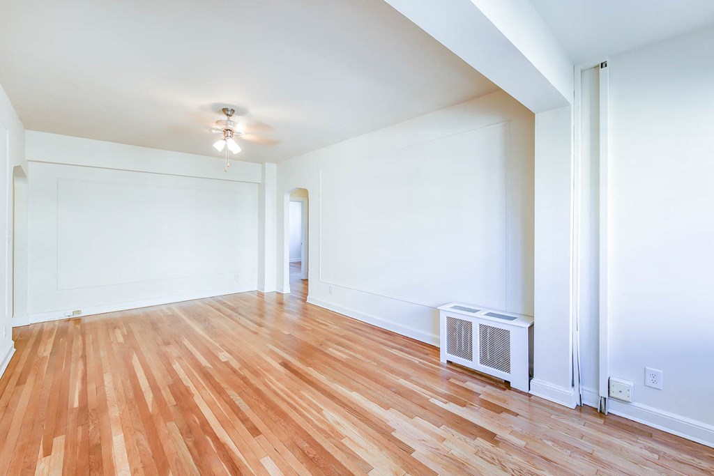 vacant living area with hardwood floors and ceiling fan at the frontenac apartments in van ness washington dc