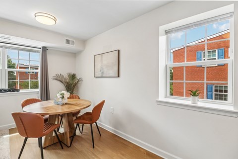 A dining room with a round table and chairs.