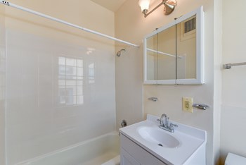 bathroom with toilet, vanity, tub, and medicine cabinet at twin oaks apartments columbia heights washington dc - Photo Gallery 21