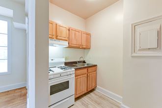 kitchen with wood cabinetry, gas range and view of living area at twin oaks apartments columbia heights washington dc