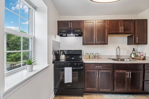 A kitchen with brown cabinets and a black oven.