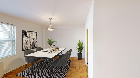 dining area with large windows, hardwood floors and table for four at clarence house apartments in washington dc