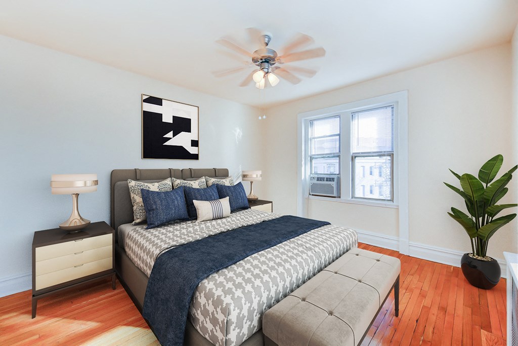 bedroom with bed, nightstand, hardwood floors, ceiling fan and large windows at chatham courts apartments in washington dc