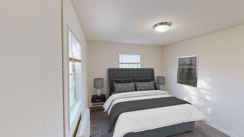 bedroom with bed, nightstand, windows and lighting at manor village tax credit apartments in washington dc