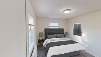 bedroom with bed, nightstand, windows and lighting at manor village apartments in washington dc