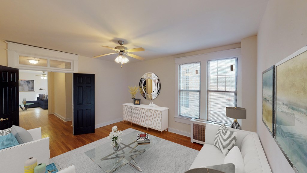 living area with sofa, coffee table, large windows, ceiling fan and view of a bedroom at the cortland apartments in washington dc