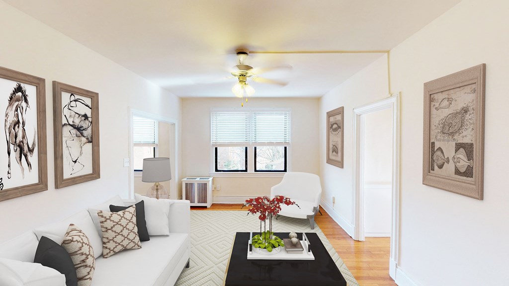 living area with sofa, seating area, coffee table, modern artwork and ceiling fan at the klingle apartments in washignton dc