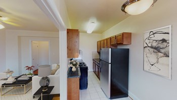 living area with sofa, coffee table and view of kitchen at the klingle apartments in washignton dc - Photo Gallery 3