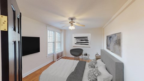 bedroom with bed, desk, large windows and tv at the cortland apartments in washington dc