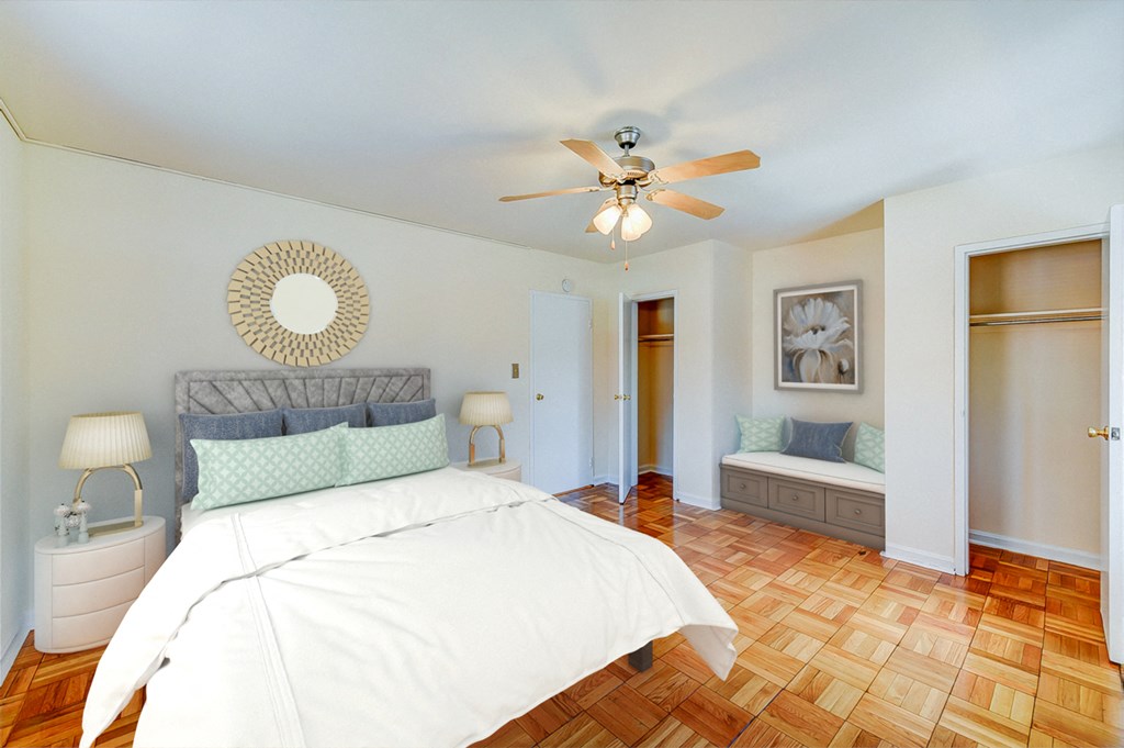 bedroom with bed, nightstands,  seating area, large closet, hardwood flooring and ceiling fan at new horizon apartments in washington dc