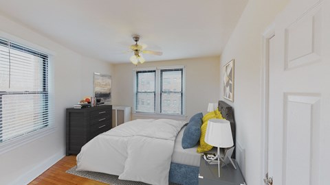 bedroom with bed, nighstands, dresser, large windows and ceiling fan at the klingle apartments in washignton dc