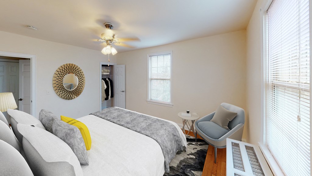 bedroom with bed, sitting area, large windows and ceiling fan at 6100 14th street in washington dc
