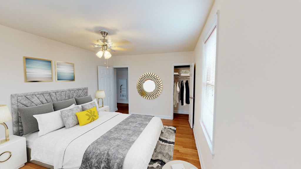 bedroom with bed, nightstands, ceiling fan, large closet and hardwood flooring at 6100 14th Street apartments in washington dc