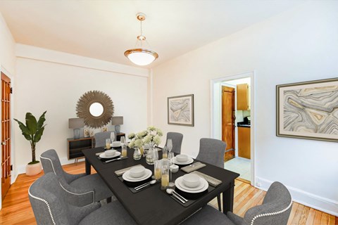 a dining room with a black table and chairs    and a living room