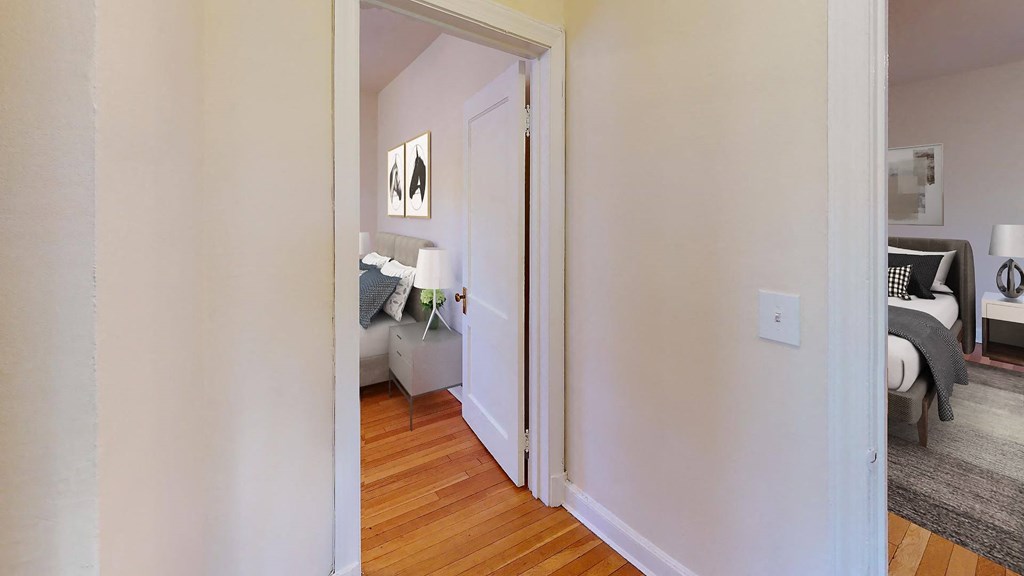 a bedroom with a bed and a door that leads to a living room