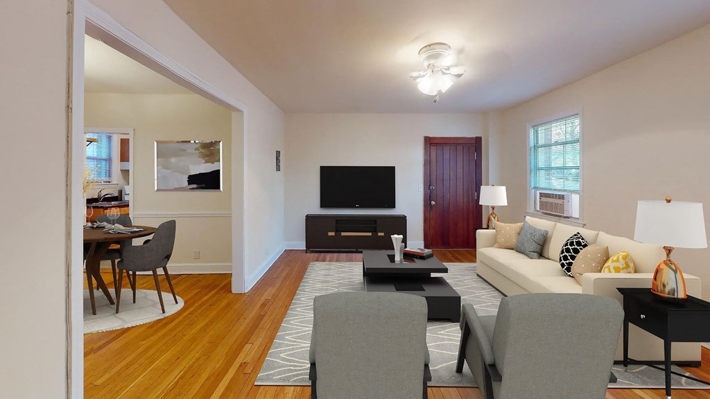 a living room with white walls and hardwood floors