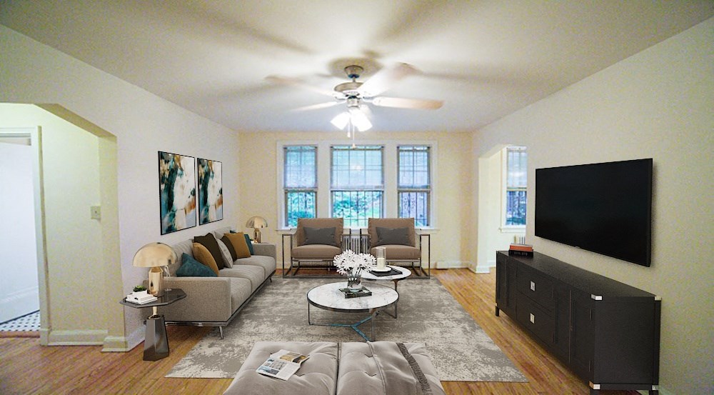 a living room with a ceiling fan and a tv on the wall at 3101 Pennsylvania apartments in washington dc