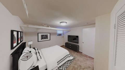bedroom with bed, plush carpeting, dresser and tv at 1818 riggs apartments washington dc