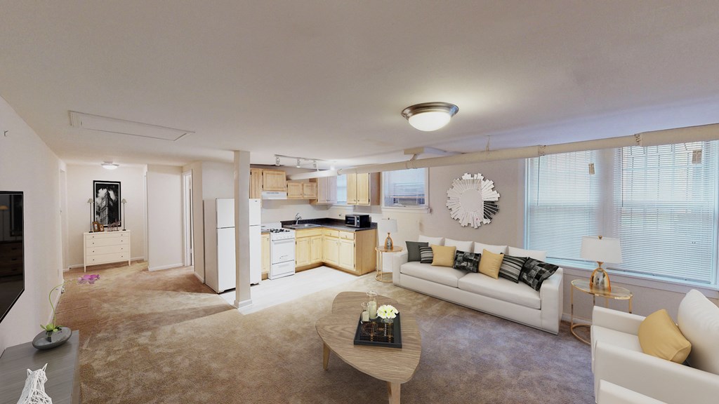 living area with large windows, sofa, coffee table, hardwood floors and view of kitchen at 1818 riggs apartments in washington dc
