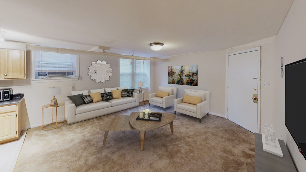 living area with large windows, sofa, coffee table, hardwood floors and view of kitchen at 1818 riggs apartments in washington dc