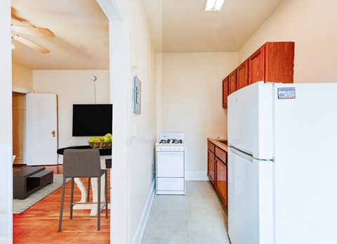 a kitchen with a white refrigerator and a table with a chair