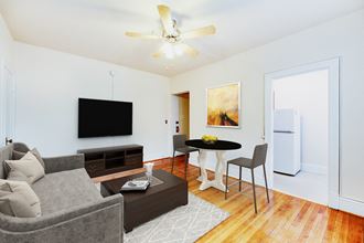 living area with sofa, coffee table, hardwood floors and view of kitchen at 1818 riggs apartments in washington dc