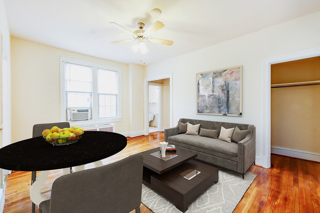 living area with sofa, coffee table, hardwood floors and large windows at 1818 riggs apartments in washington dc