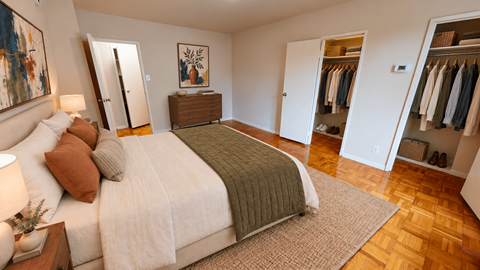 A bedroom with a large bed and a wooden dresser.