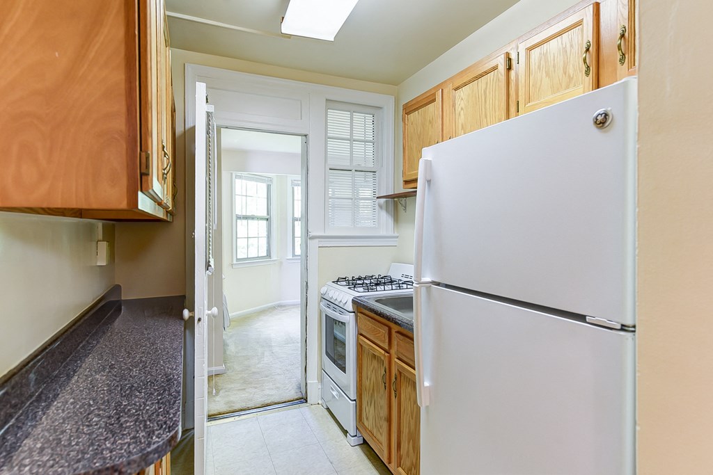 kitchen with tile flooring, wood cabinetry, energy efficient appliances, gas range and window at  2629 39th Street apartments in washington dc