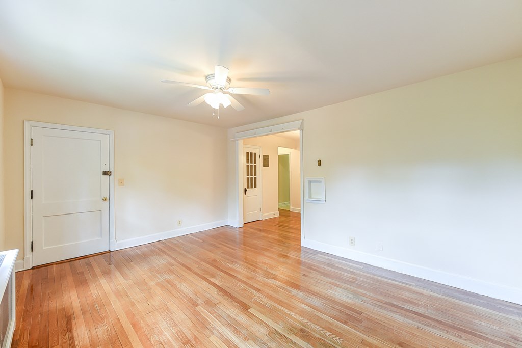 vacant living area with hardwood floorings, ceiling fan and view of hallway  at  2629 39th Street apartments in washington dc