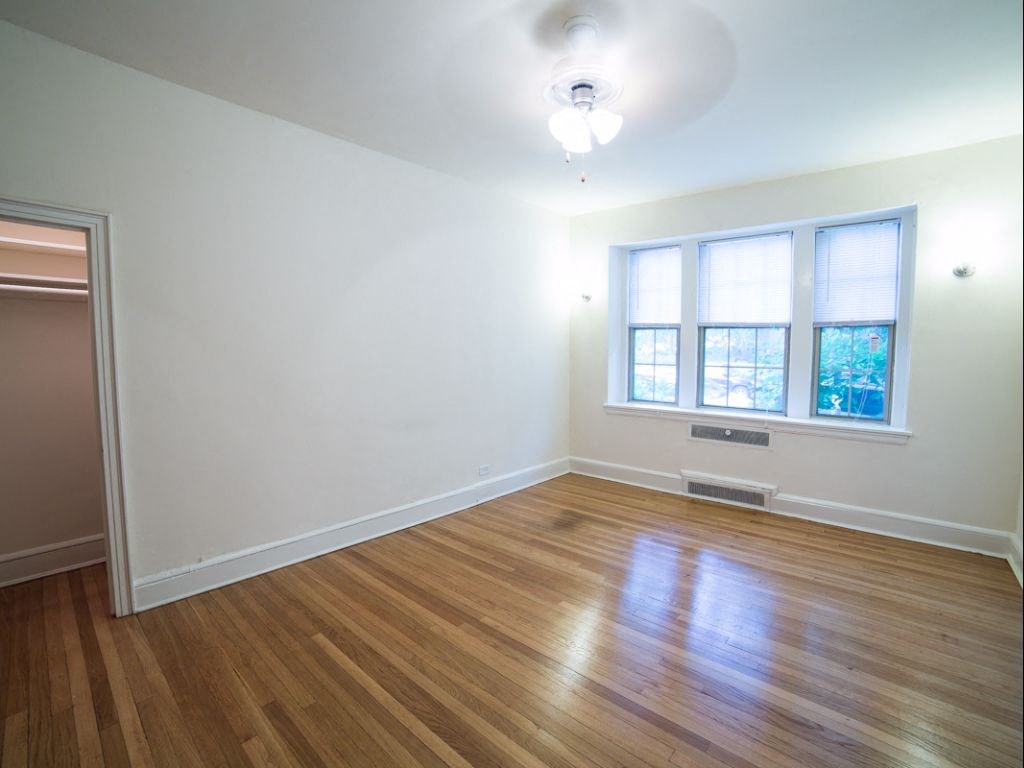 vacant bedroom with hardwood flooring and ceiling fan at 2800 ontario road apartments in washington dc