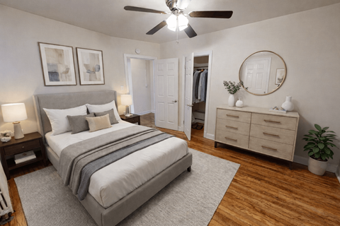 A bedroom with a large bed, a dresser, and a ceiling fan.