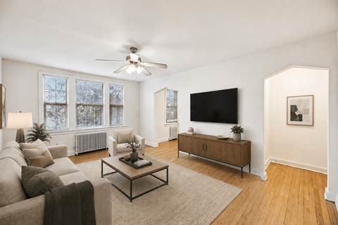 A living room with a couch, a coffee table, and a flat screen TV.