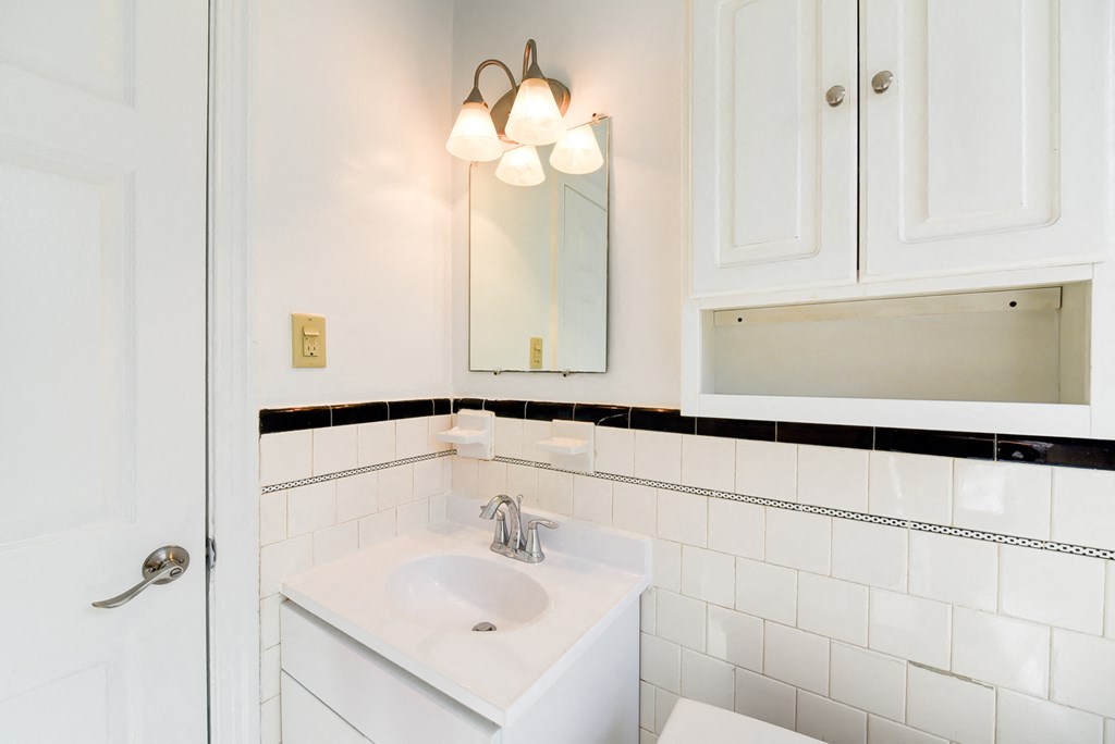bathroom with cabinet, vanity, sink and mirror at 3101 Pennsylvania apartments in washington dc