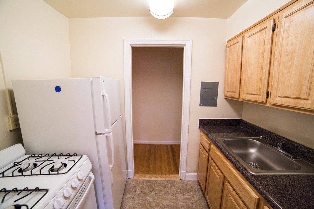kitchen with gas range, oak cabinetry, and view of hallway at 3101 pennsylvania apartments in washington dc