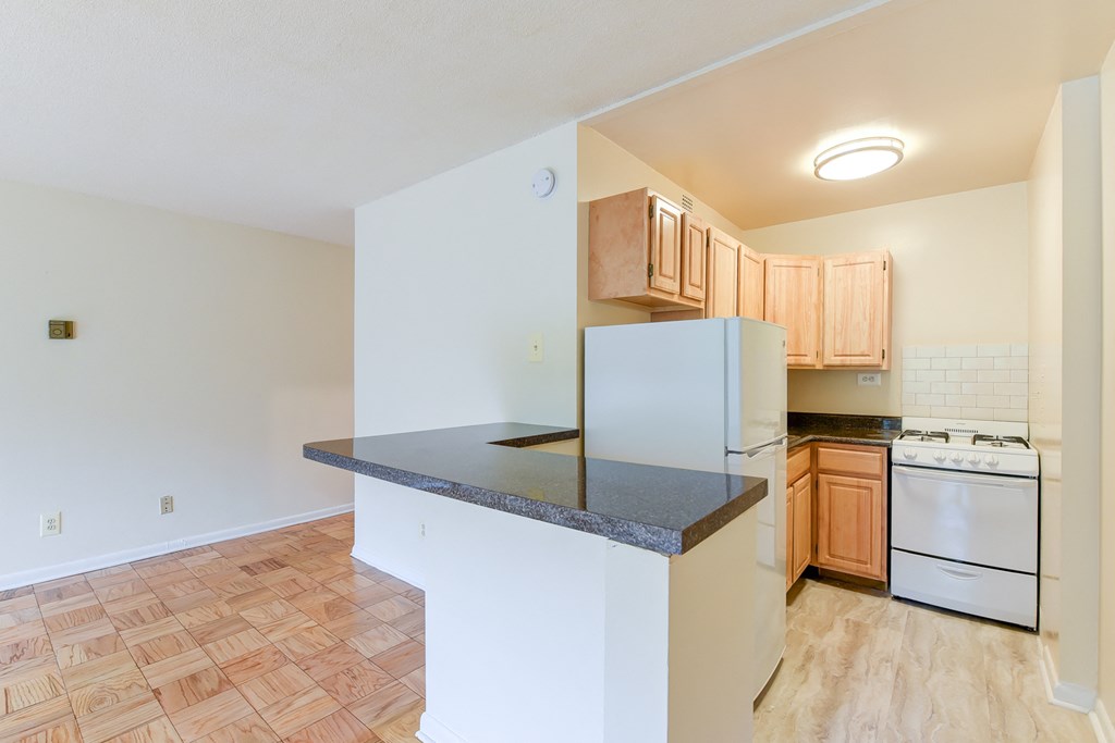 kitchen with wood cabinetry, gas range and breakfast bar at twin oaks apartments columbia heights washington dc