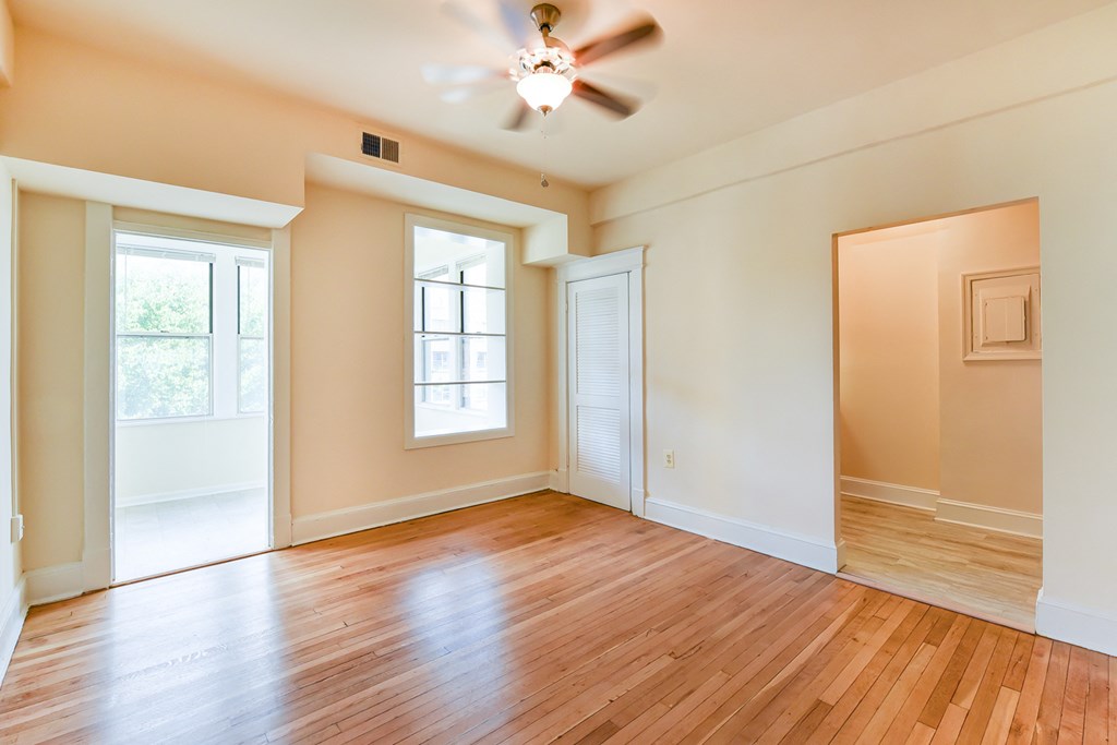 vacant living area with hardwood flooring, large windows and ceiling fan  at twin oaks apartments columbia heights washington dc