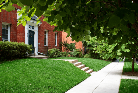 A red brick house with a white door and windows.