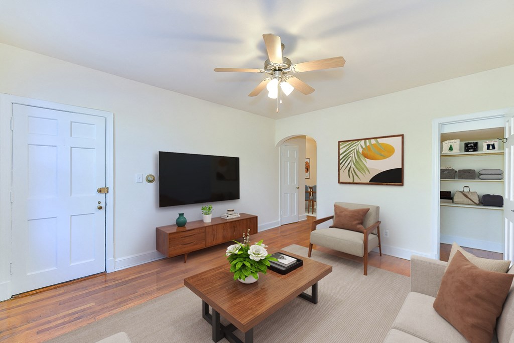 a living room with a ceiling fan and a television