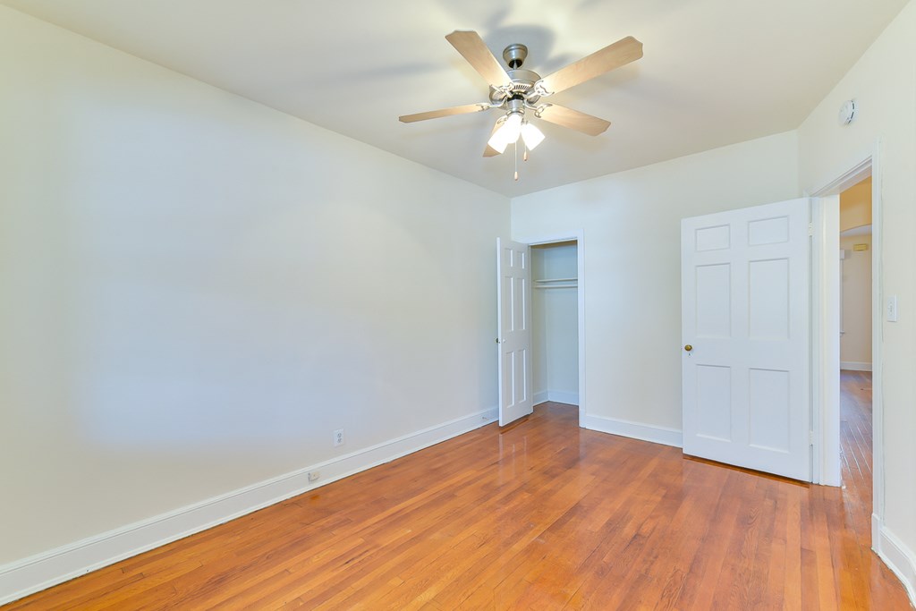 vacant bedroom with hardwood flooring, closet and ceiling fan at 4020 calvert street apartments in washington dc
